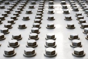 Bolts on a fragment of a massive girder bridge gray. Original background.